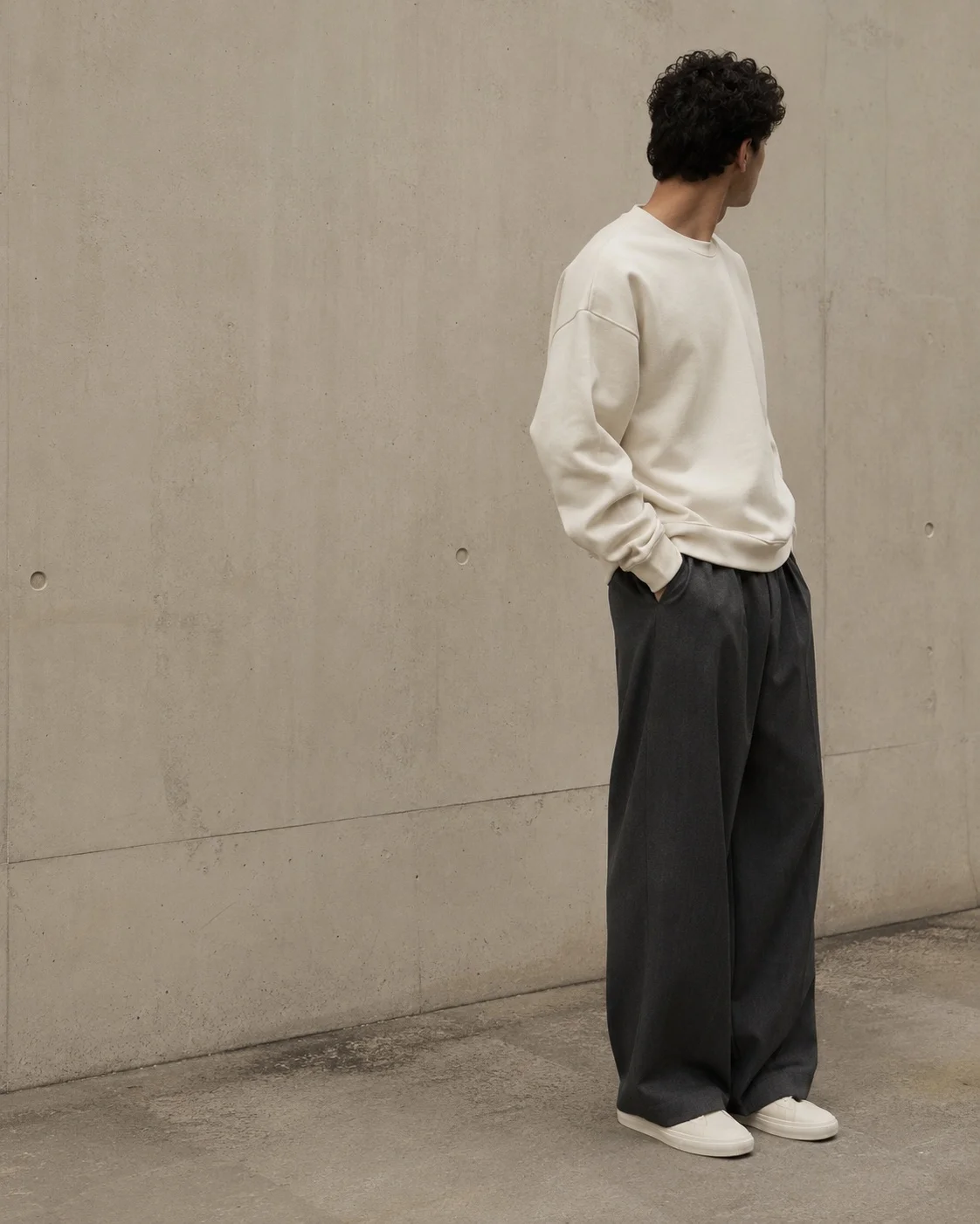 K.A. Elegance – Person in cremefarbenem Oversized-Sweatshirt und weiter Anthrazit-Hose